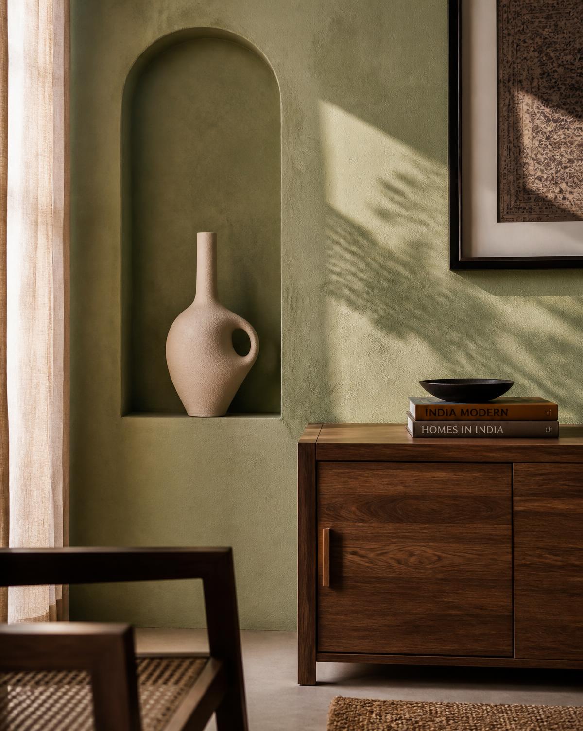 Textured plaster wall with an arched niche and a single ceramic vessel